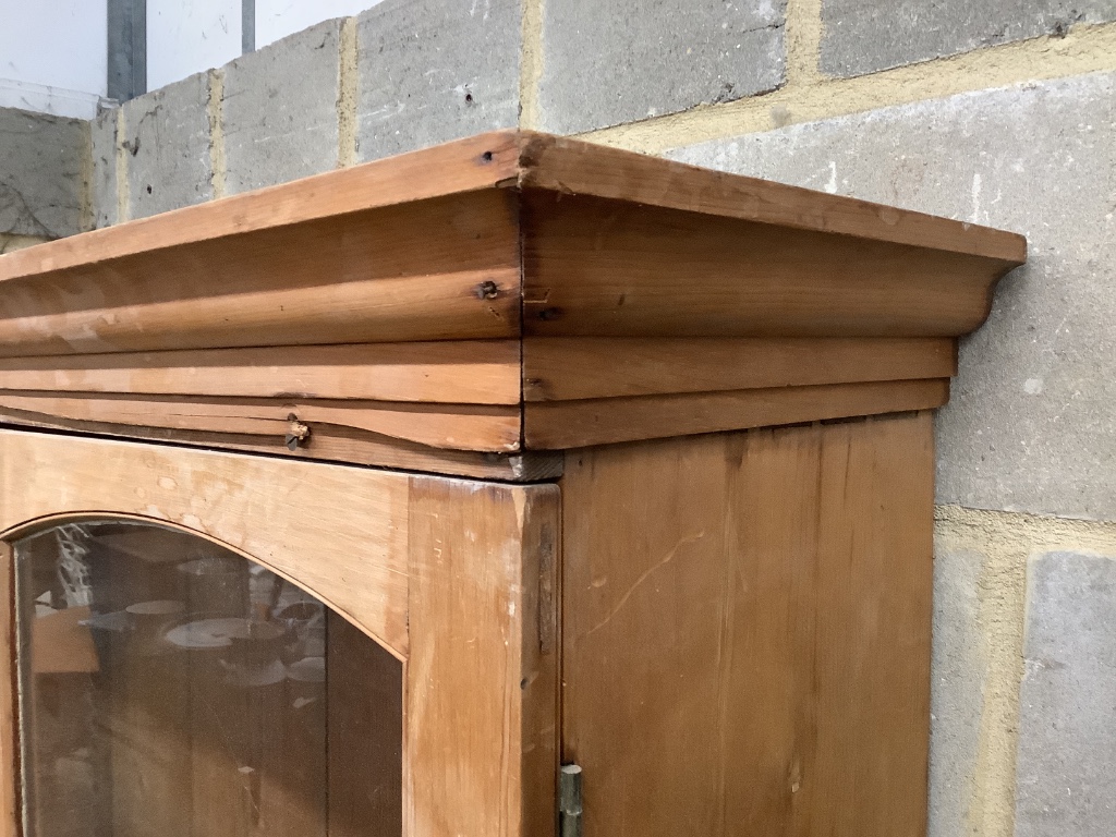 A glazed pine bookcase / cupboard, width 106cm, depth 46cm, height 196cm